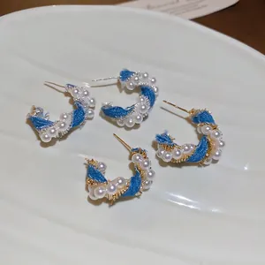 Elegant C-shaped earrings with blue denim wrap, faux pearls and golden wire twist