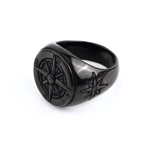 Detailed close-up of retro compass seal ring with NESW engraved letters in dark metal