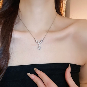 Dettaglio di una collana geometrica con zircone indossata su una modella donna