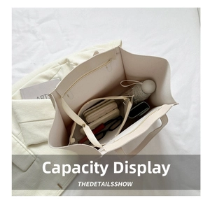 Top view showing the large capacity and interior pouch of the off-white tote bag