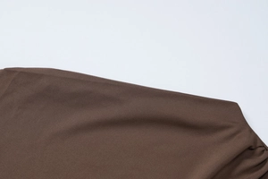 Detailed view of dark brown dress showing fine stitching and twill fabric texture