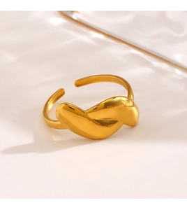 Detailed view of irregular golden twisted metal ring with polished finish and open design