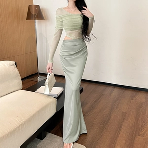 Detail of light green mesh sleeves and satin high-waisted skirt texture on a dress