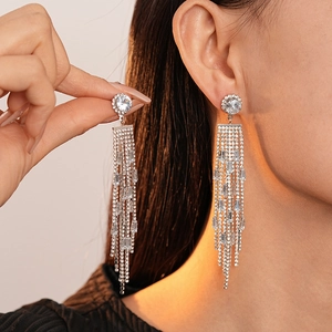 Elegant silver tassel earrings with zircon diamonds worn by a model in a side profile view