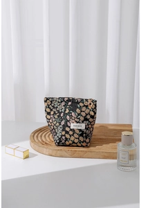 Detailed close-up of a floral makeup bag featuring a jacquard pattern and branded label