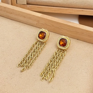 Vintage gold tassel earrings with amber square gemstones in a beige jewelry display box