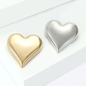 Elegant gold and silver heart-shaped alloy brooches on a white display stand