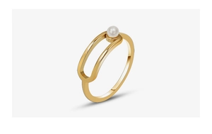 Macro detail of gold-plated geometric ring featuring a white pearl on a hollow oval band
