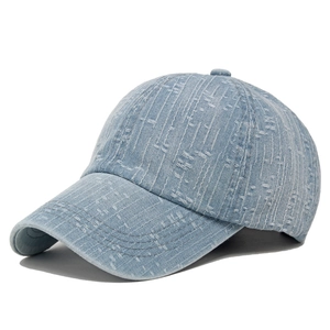 Detailed view of light blue denim baseball cap featuring distressed jacquard texture