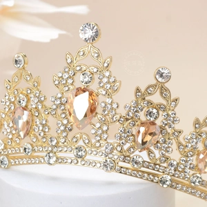 Macro shot of luxury gold crown featuring large champagne pear-cut rhinestones and crystals