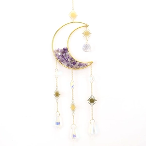 Close-up of golden moon sun catcher with purple amethyst stones and crystal prisms