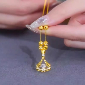 Macro detail of gold-plated skirt-shaped pendant with cubic zirconia on link chain