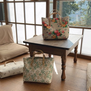 Vintage floral cotton tote bag with premium leather handles in a cozy home setting