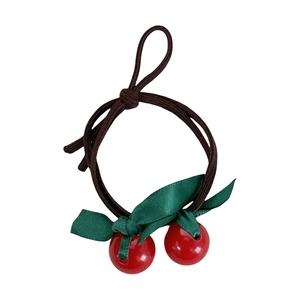 Cute cherry bow hair tie with red beads and green ribbons on brown elastic band