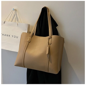 Detailed view of khaki large capacity leather tote bag with smooth matte finish and seams