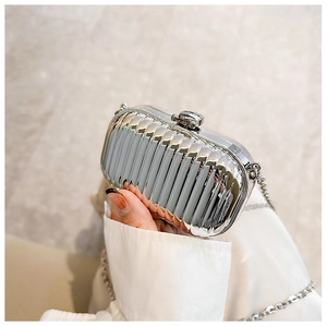 Detail of silver metallic evening bag with vertical ripple texture and chain strap