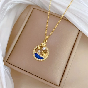 Detailed macro view of gold-plated star and pearl pendant on a luxury chain necklace