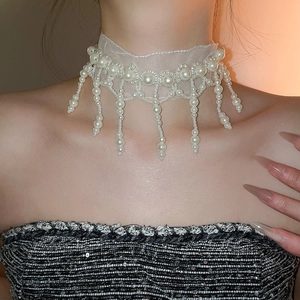 Close-up of elegant mesh lace choker with hanging pearls and vintage fringe details