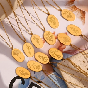 Detail of irregular oval gold pendants with intricate engraved flower patterns