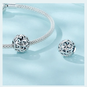 Macro shot of S925 sterling silver hollow floral bead on a woven snake chain bracelet