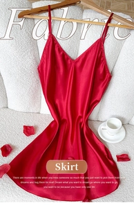 Détail d'une nuisette en satin rouge sur cintre avec des pétales de rose épars