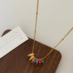Ethnic style gold necklace with seven colorful enamel circle pendants in rainbow tones