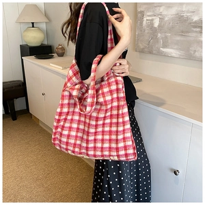 Detailed view of red and white checkered tweed tote bag with Howell branding detail