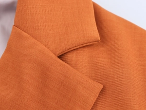 Detailed macro view of the caramel woven fabric and stitching on the elegant suit collar