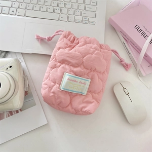 Pink quilted drawstring camera pouch showing soft cloud fabric texture and woven cords