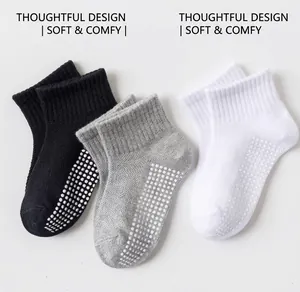 Close-up of anti-slip cotton baby socks with rubber dots in white, gray and black colors