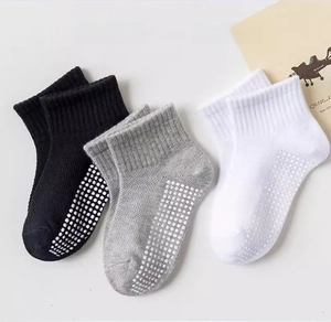 Close-up of anti-slip cotton baby socks with rubber dots in white, gray and black colors