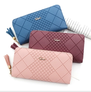 Three long zipper wallets in blue, red, and pink featuring tassel details and diamond quilting