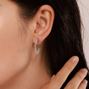 Silver C-shaped starburst earrings with sunray texture shown on a female model