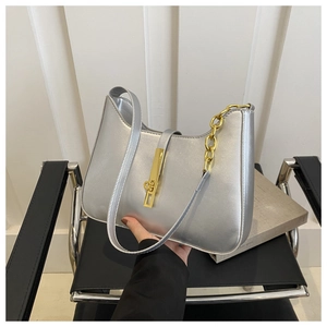 Detailed close-up of a silver semi-circular underarm bag with gold chain and metal clasp