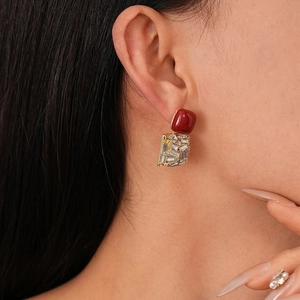 Detail of vintage red acrylic earrings with gold metal frame and sparkling crystal accents