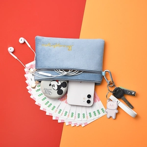 Close-up of a light blue plush makeup bag with gold embroidery and interior storage space