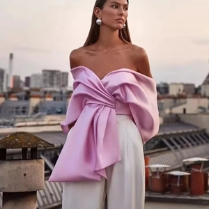 Détail du haut en satin à épaules dénudées rose poudré avec plis élégants et reflets