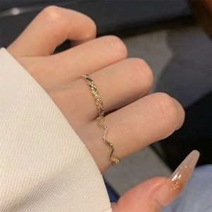 Detail of gold plated twisted wave rings with micro-set zircon on model hand