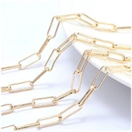 Macro shot of gold paperclip chain link detail with a polished metallic finish