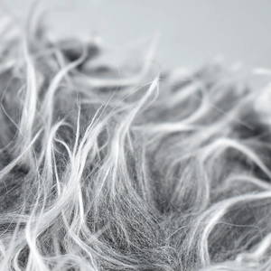 Macro shot of gray and white faux fur texture on the camouflage wig baseball cap