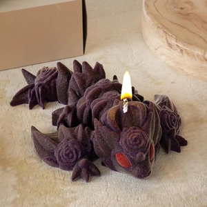 Deep purple dragon candle with rose relief textures and a burning spiral candle