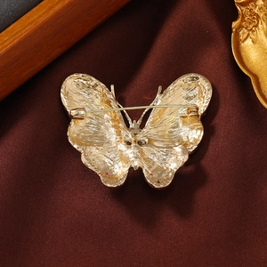 Elegant gold butterfly brooch with rhinestone inlay shown from the back perspective