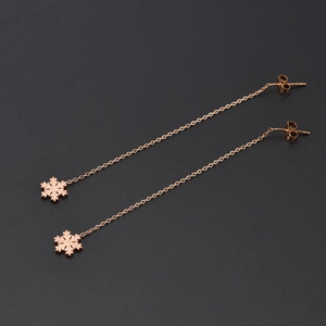 Elegant 18k rose gold snowflake drop earrings with frosted and mirror finish on black background