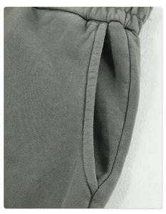 Nahaufnahme der olivgrünen Hoodie-Textur mit verstärkten Nähten und Taschendetails