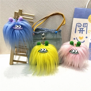 Set of three colorful fuzzy monster plush keychains with big eyes and funny smiles