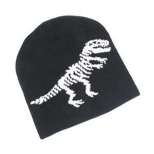 Detail of knitted dinosaur skeleton pattern on black winter beanie for boys