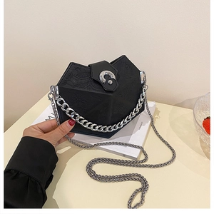 Detailed macro of black polygonal embossed leather bag with silver chain strap and buckle
