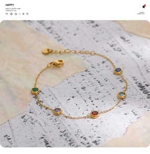 Close-up of golden stainless steel chain with five colorful gems and adjustable lobster clasp