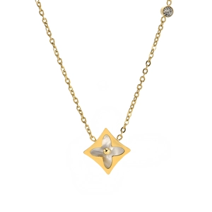 Macro shot of gold layered necklace featuring mother of pearl flower pendant and zircon