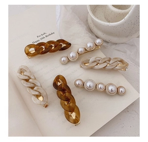 Detailed shot of a 5-piece hair clip set featuring pearls and resin chain links